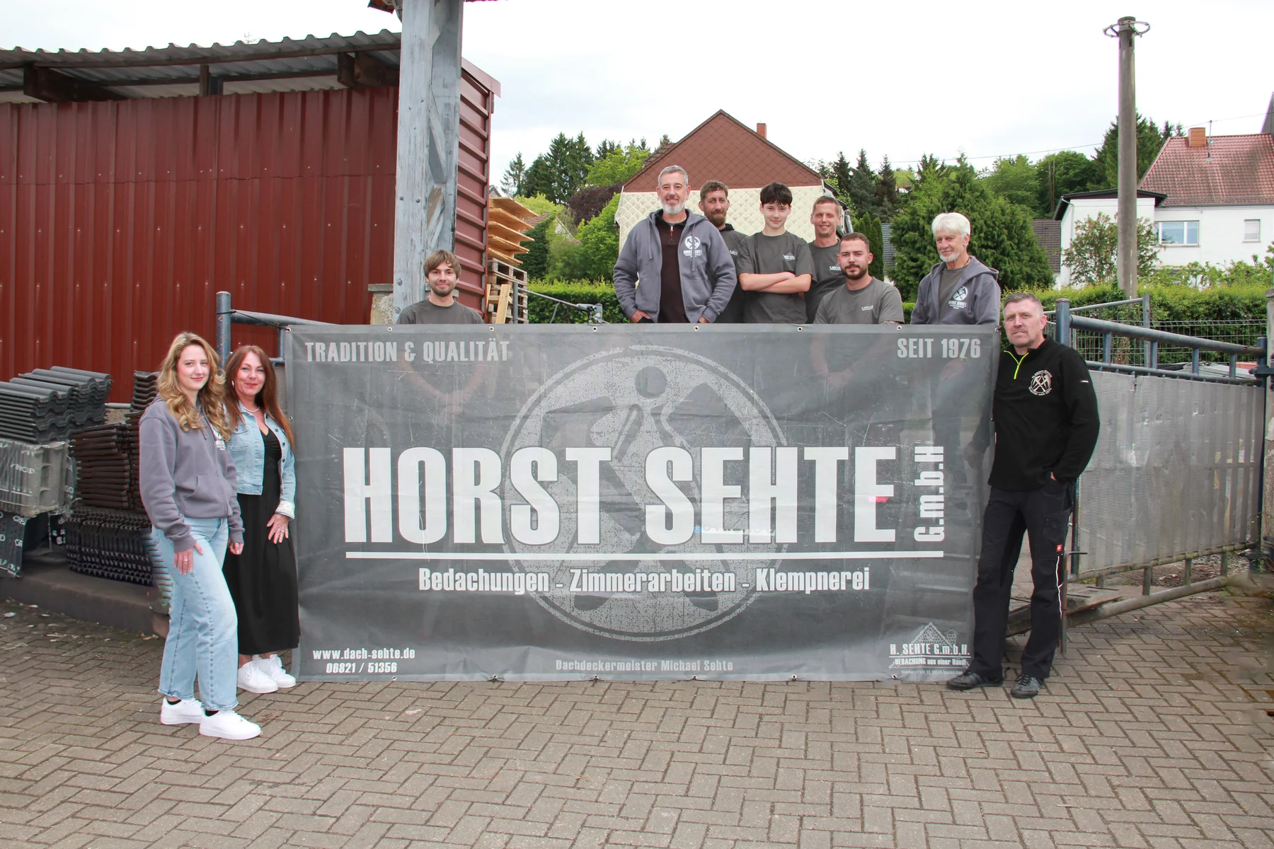 Das Team der Horst Sehte GmbH vor dem Firmenbanner